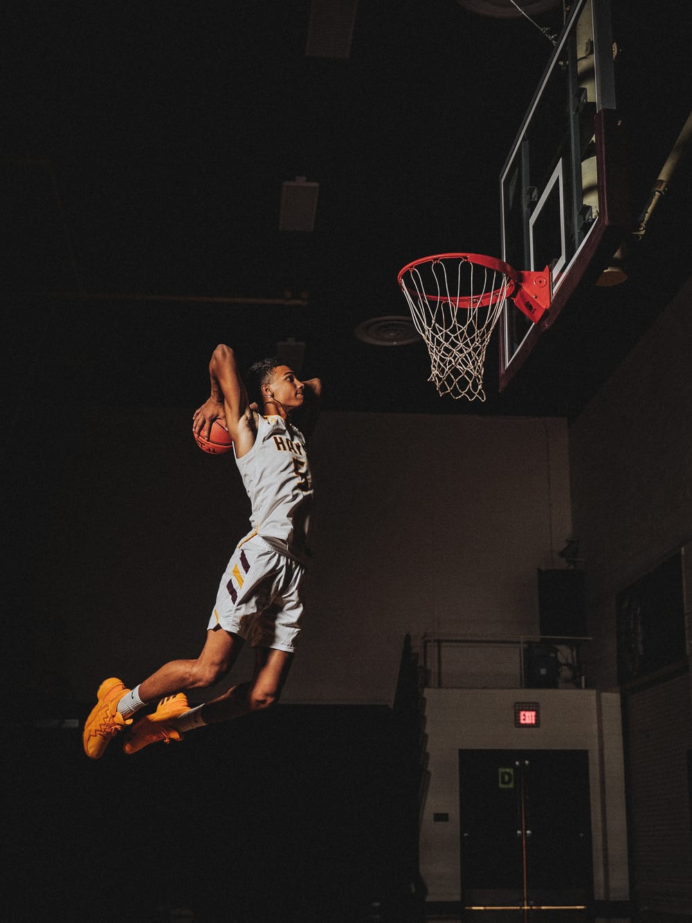 Basketball player rising to the rim for a two-handed dunk